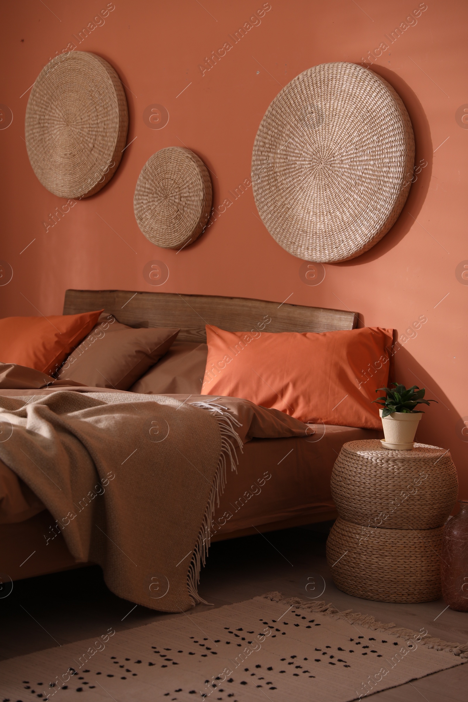 Photo of Bed with orange and brown linens in stylish room