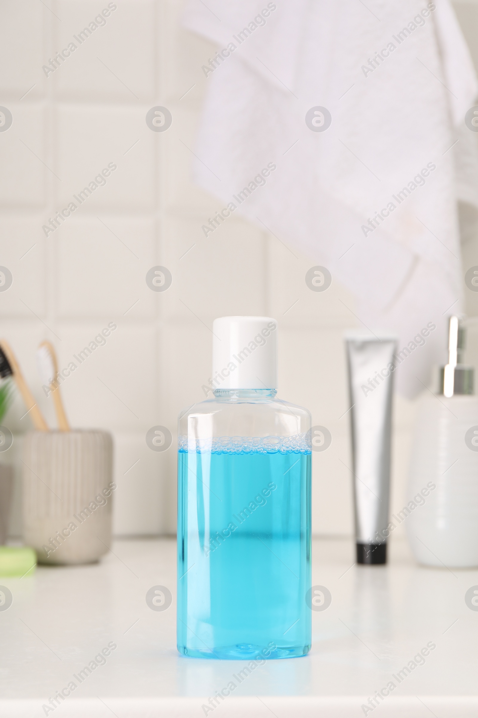 Photo of Bottle of mouthwash on white table in bathroom