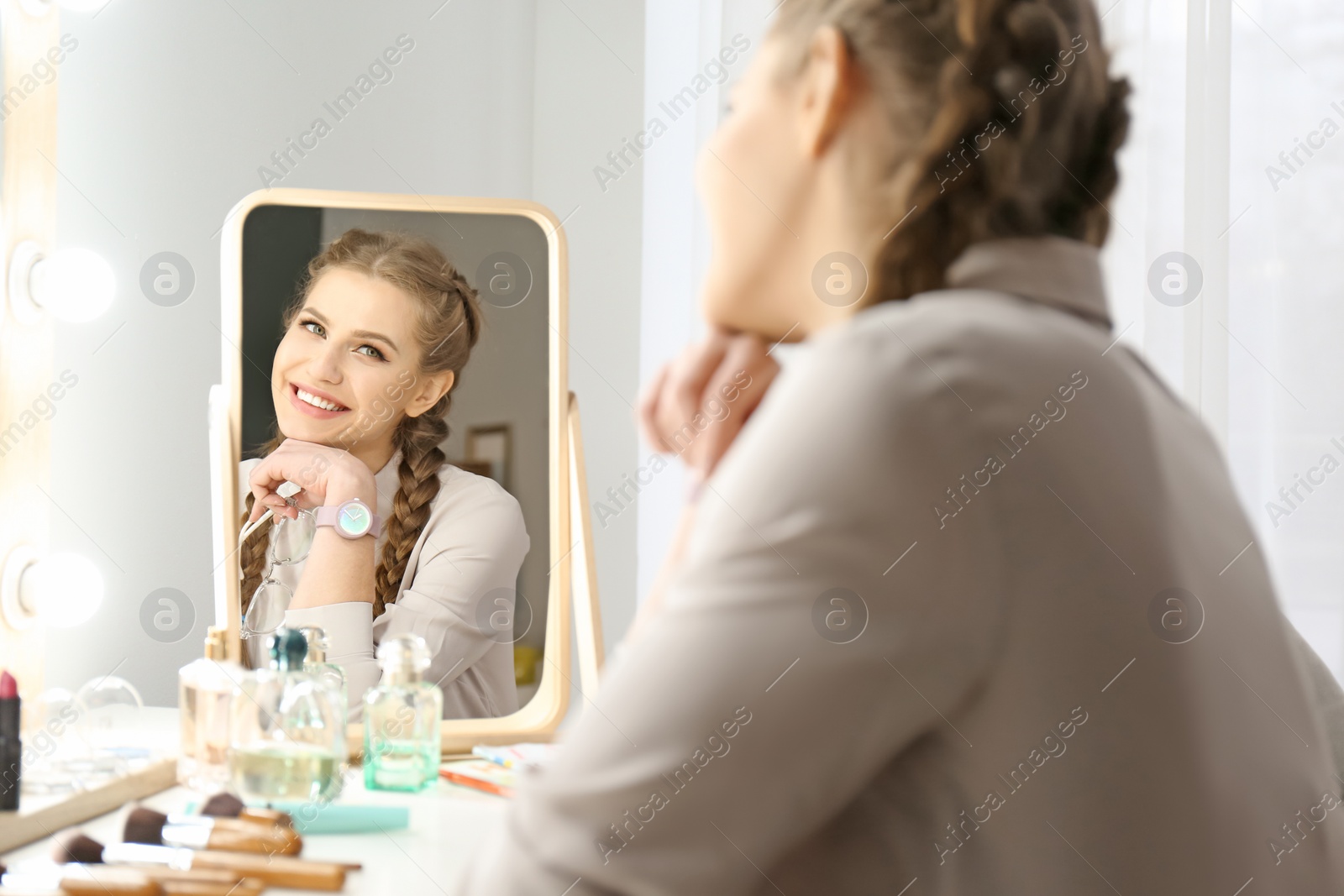 Photo of Portrait of beautiful woman with natural makeup near mirror indoors