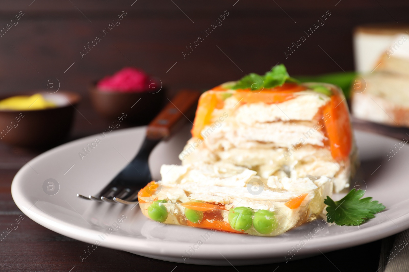 Photo of Delicious chicken aspic served on wooden table, closeup