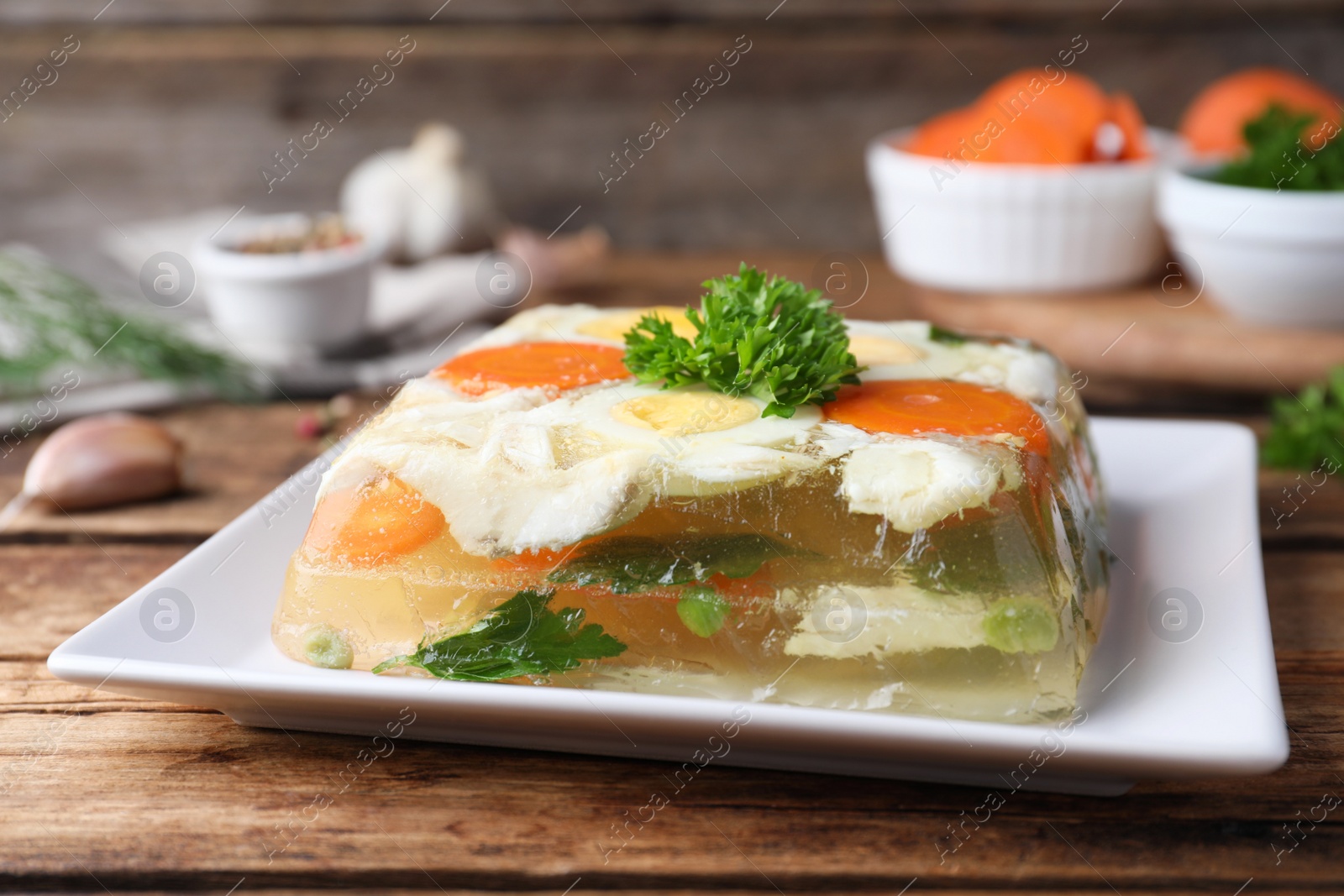 Photo of Delicious fish aspic served on wooden table, closeup