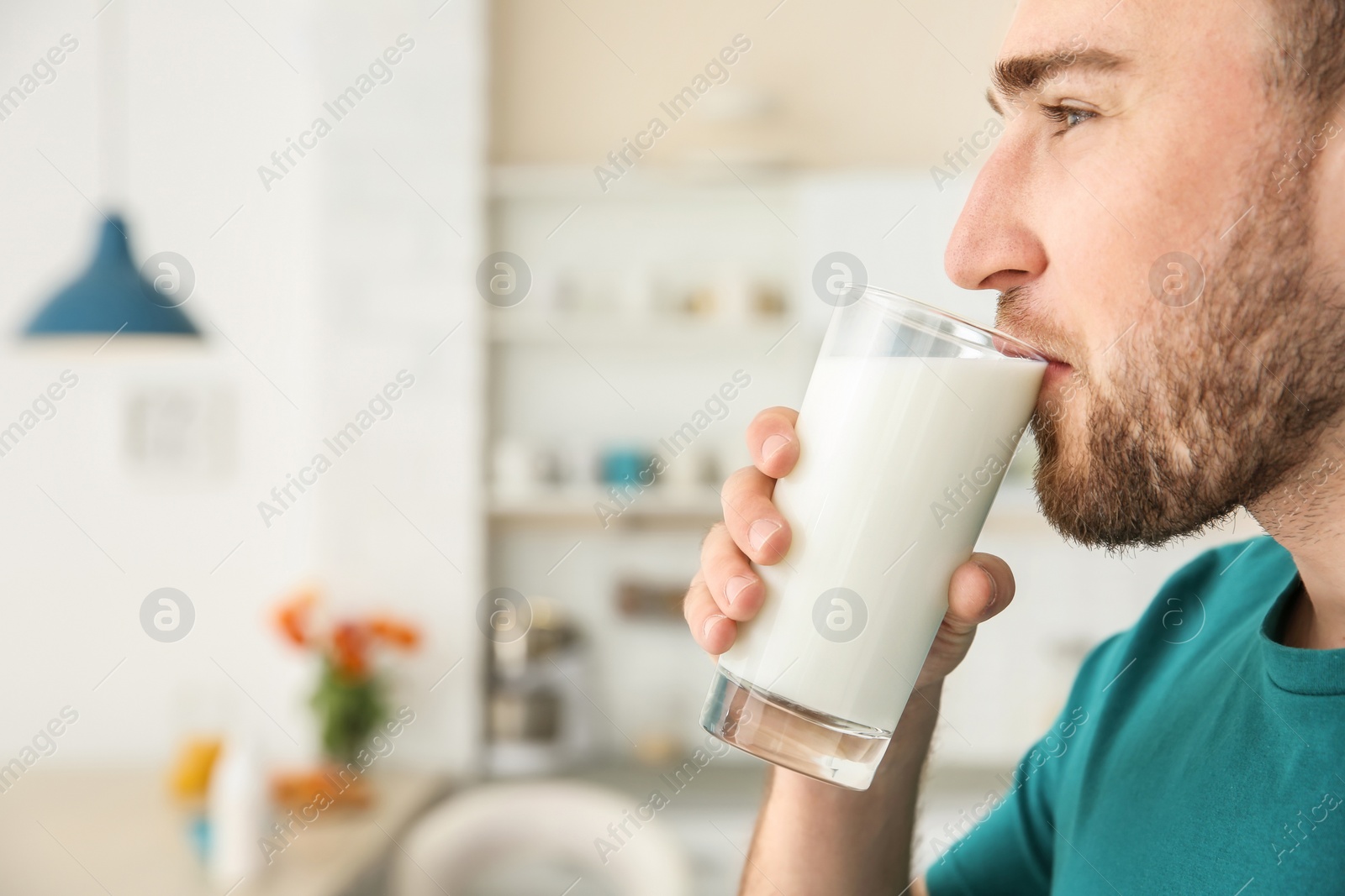 Photo of Young man drinking tasty milk at home