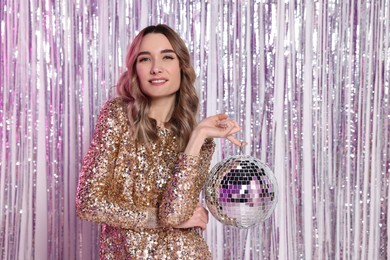 Photo of Beautiful woman in golden dress with disco ball at party