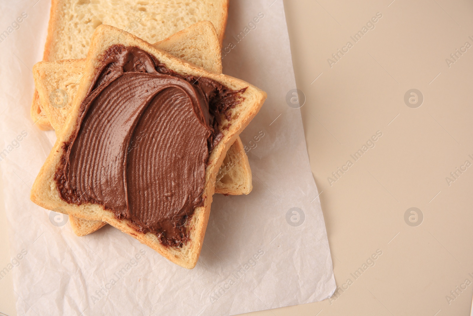 Photo of Tasty toast with chocolate paste on light background, top view. Space for text