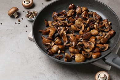 Photo of Frying pan with mushrooms on grey table
