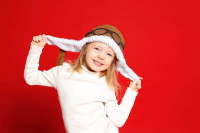Portrait of cute little girl on red background