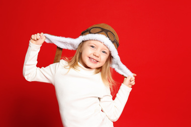 Photo of Portrait of cute little girl on red background