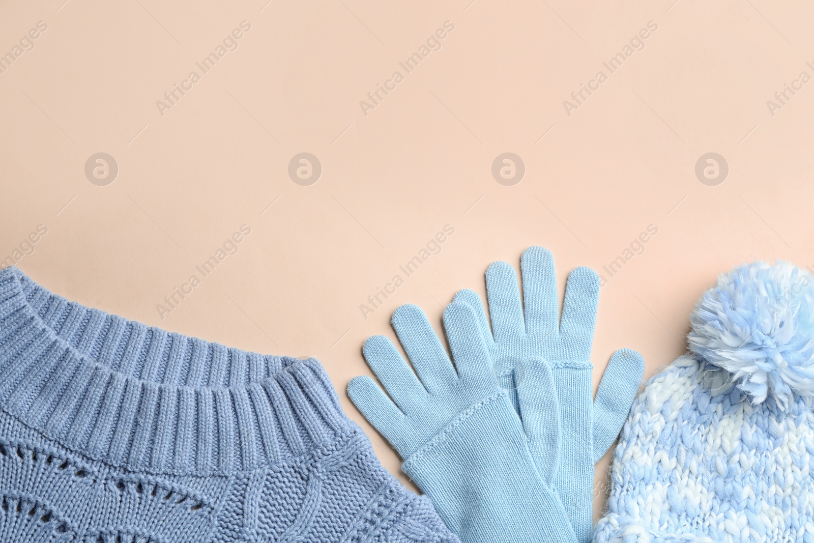 Photo of Flat lay composition with warm clothes on beige background. Space for text