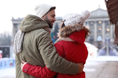 Photo of Happy young couple spending time together at winter fair. Christmas celebration