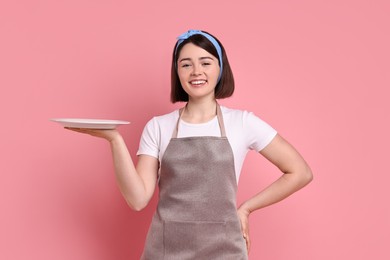 Photo of Happy confectioner with plate on pink background