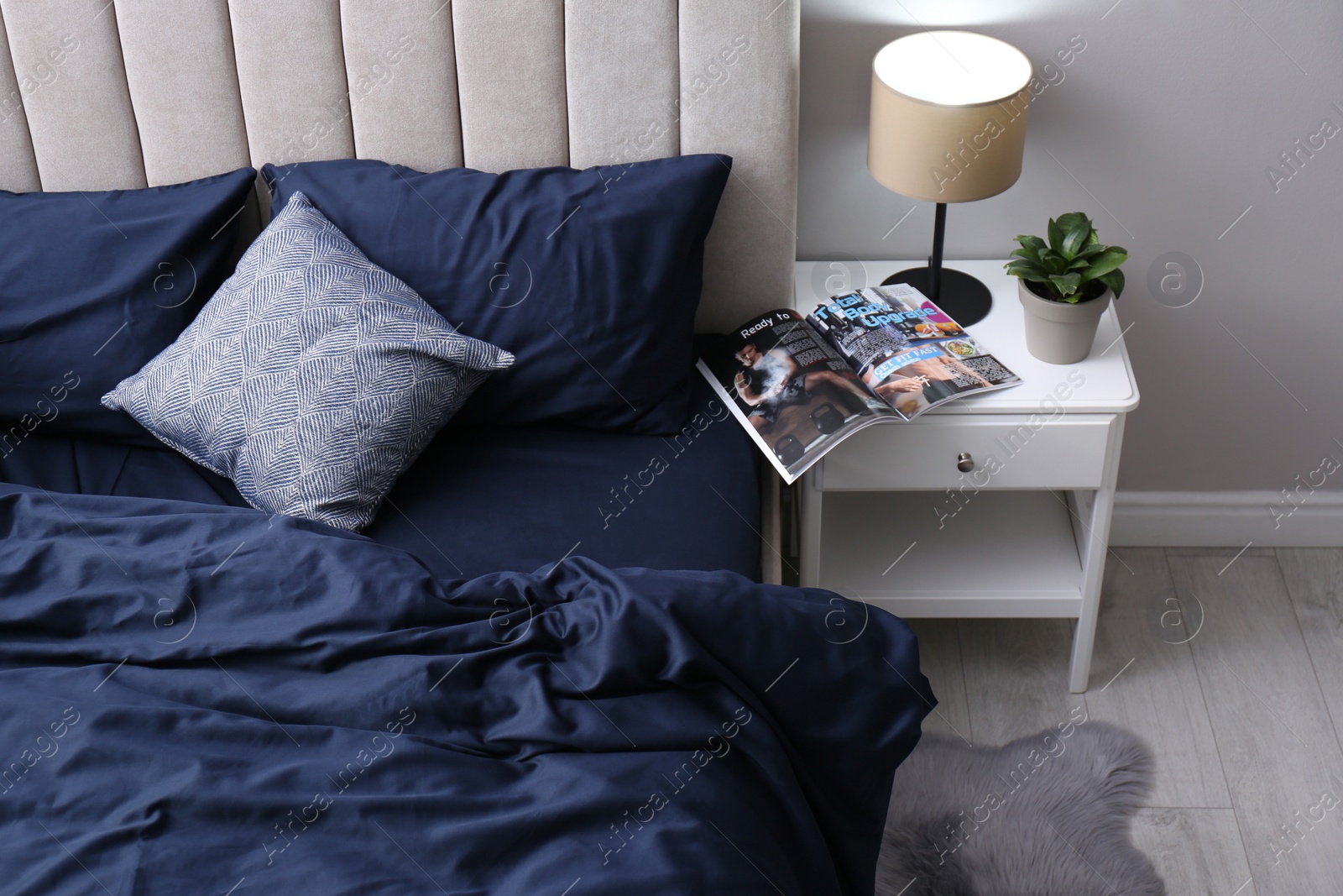 Photo of Bed with stylish silky linens in room