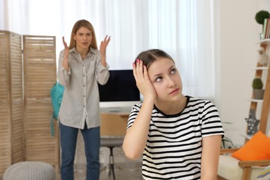 Photo of Teenage daughter ignoring mother while she scolding her at home