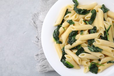 Photo of Tasty pasta with spinach and sauce on grey table, top view. Space for text