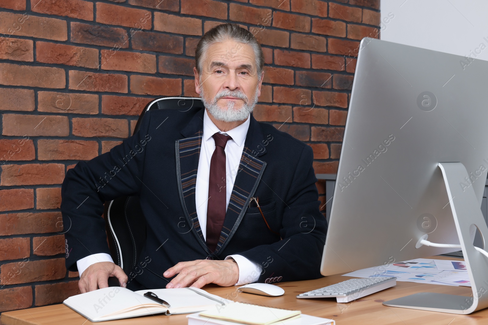 Photo of Successful senior boss working in his office