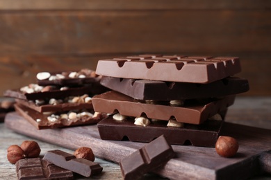 Different delicious milk and dark chocolate bars on table