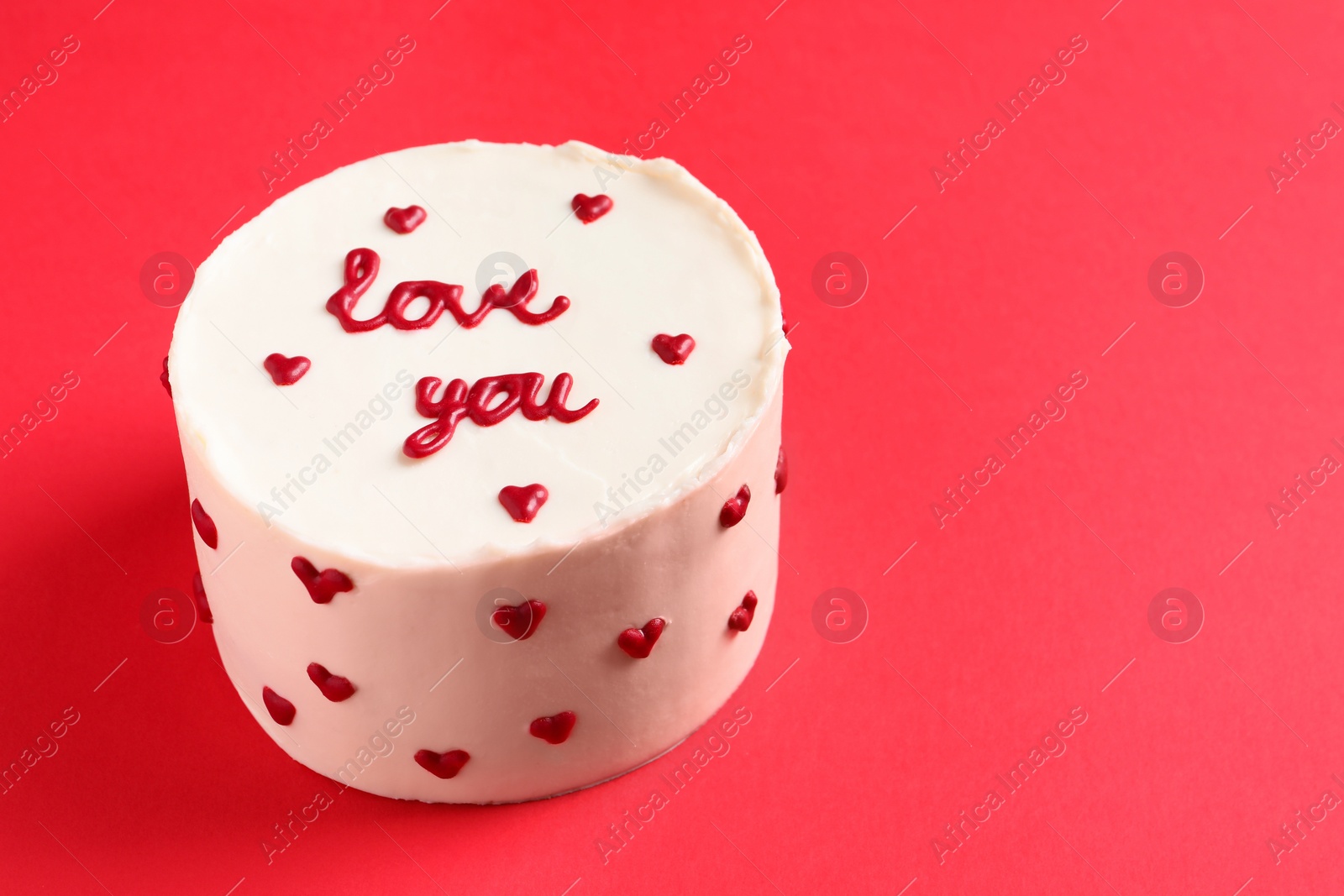 Photo of Bento cake with text Love You on red table, space for text. St. Valentine's day surprise