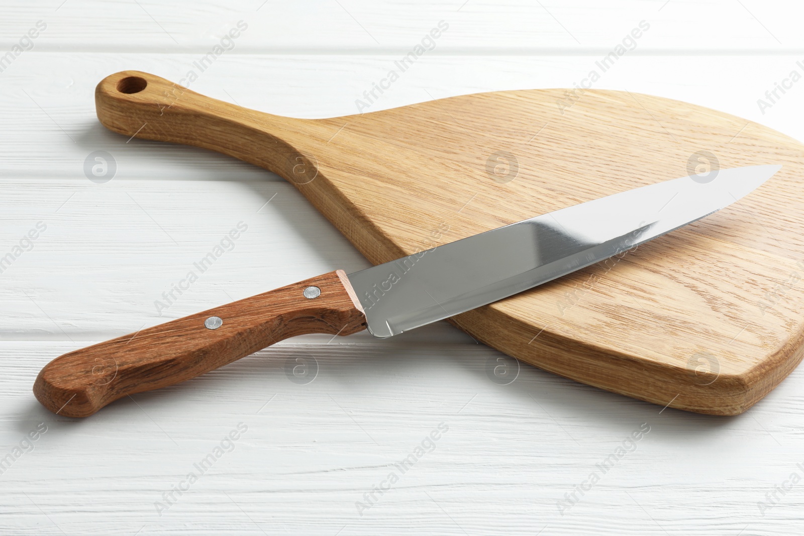 Photo of One sharp knife on white wooden table, closeup