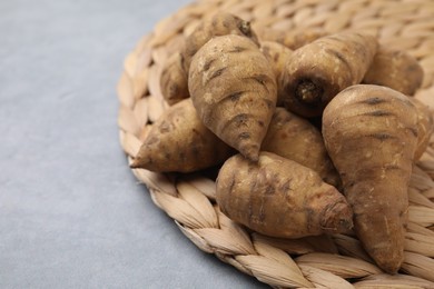 Photo of Tubers of turnip rooted chervil on gray table, closeup. Space for text