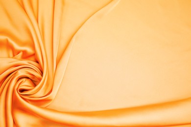 Texture of delicate orange silk as background, top view