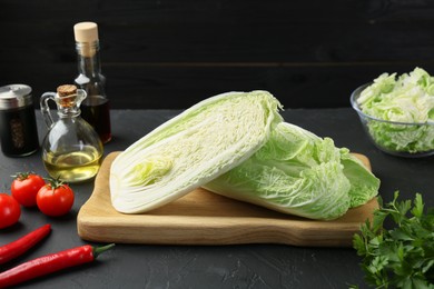 Fresh Chinese cabbages and other products on black textured table