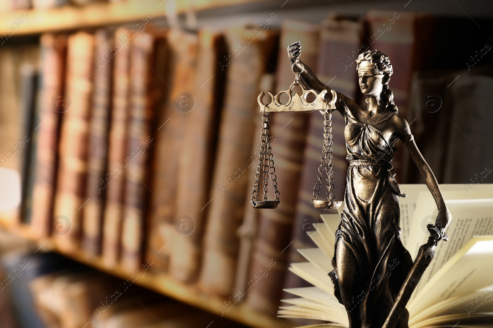 Image of Law. Statue of Lady Justice near shelf with books indoors, space for text