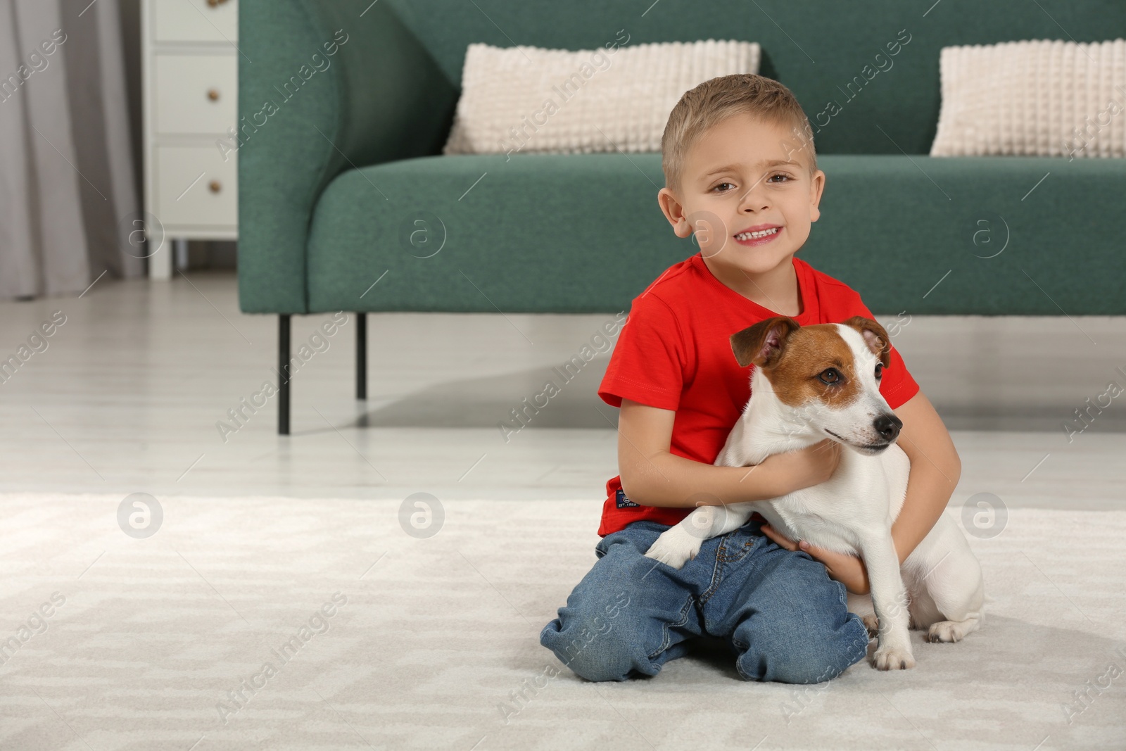 Photo of Little boy with his cute dog on floor at home, space for text. Adorable pet