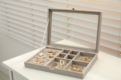 Elegant jewelry box with beautiful bijouterie on white table indoors