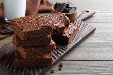 Delicious chocolate brownies on wooden table. Space for text