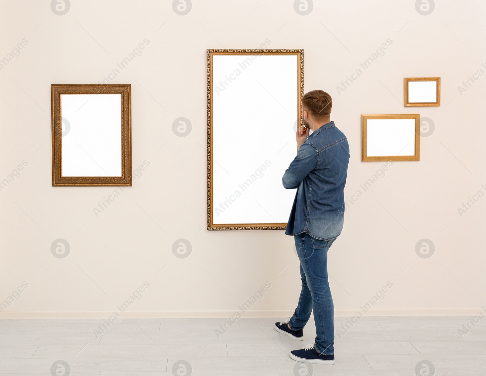 Photo of Young man viewing exposition in modern art gallery