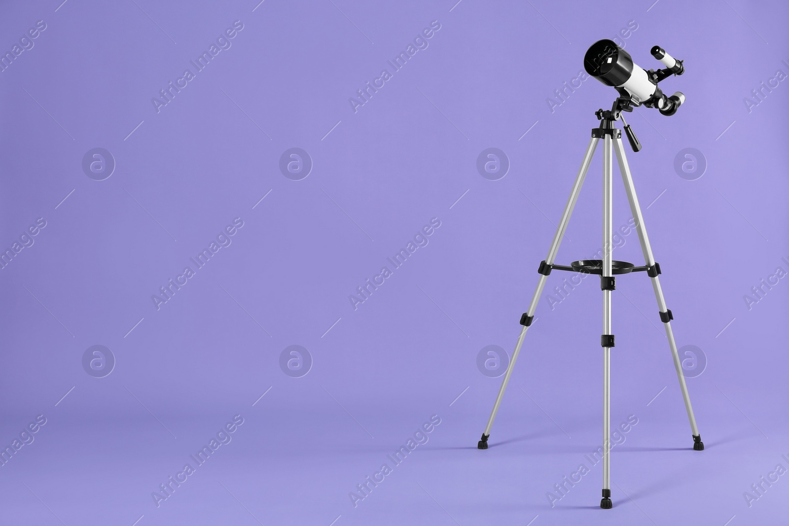 Photo of Tripod with modern telescope on light purple background, space for text