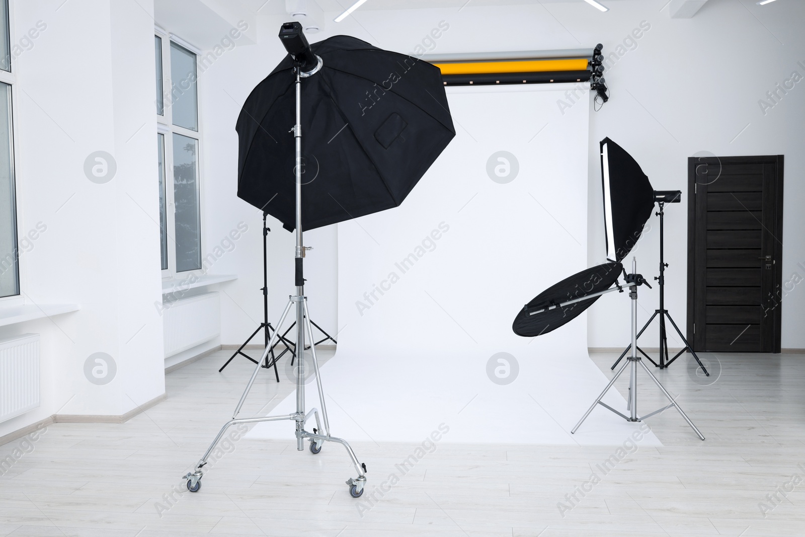 Photo of Interior of modern photo studio with professional lighting equipment