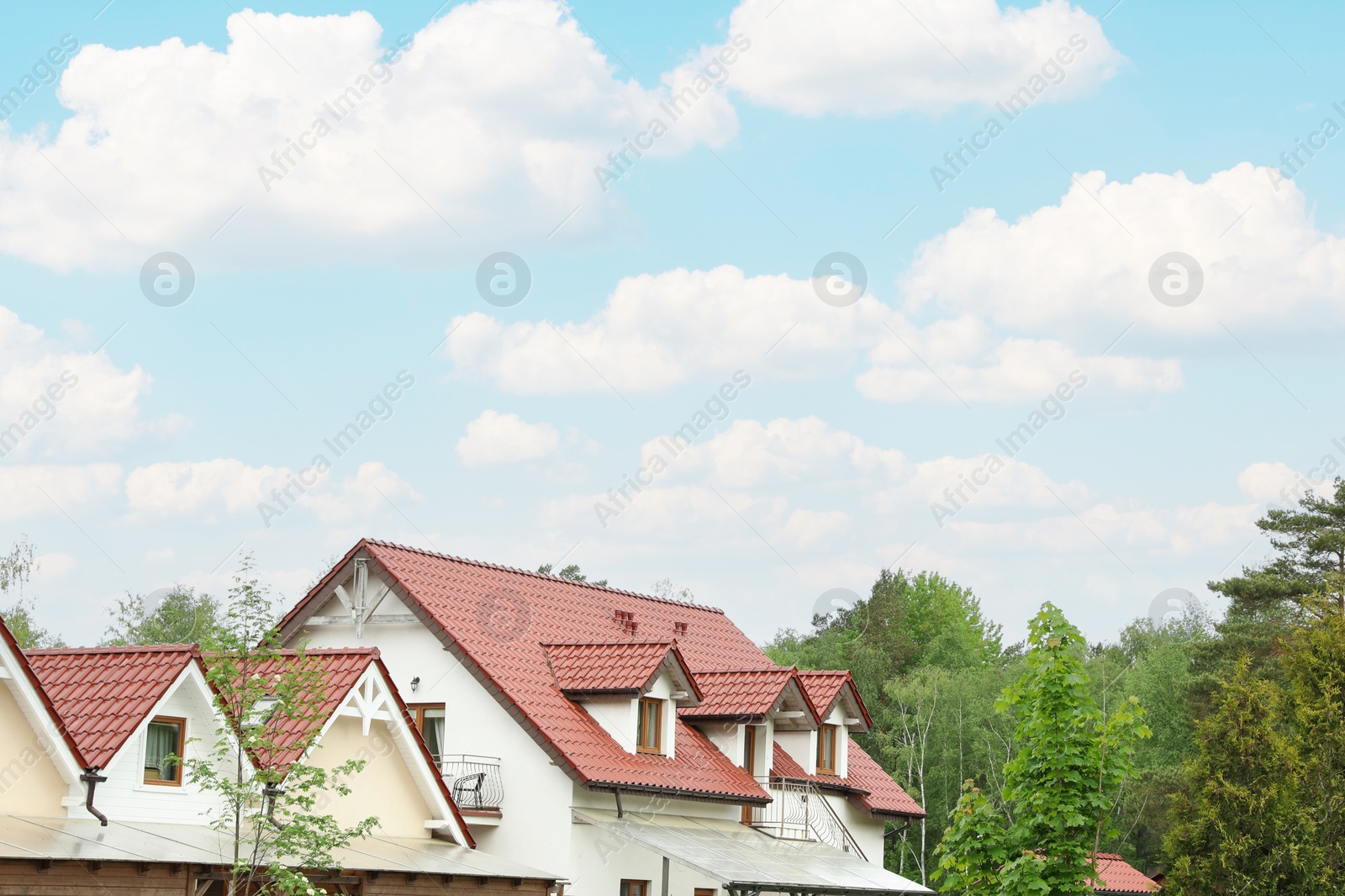 Photo of Modern buildings with red roofs near forest on spring day