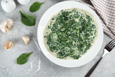 Photo of Tasty spinach dip on grey marble table, flat lay