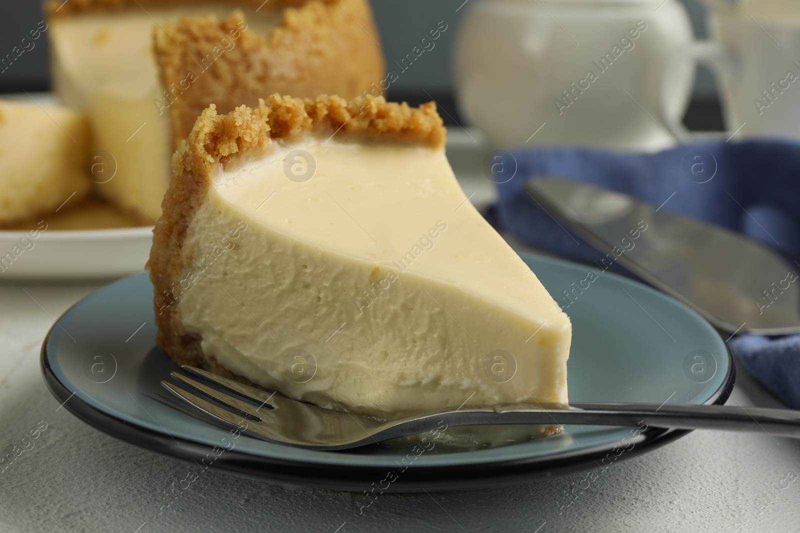 Photo of Piece of tasty vegan tofu cheesecake and fork on white table, closeup