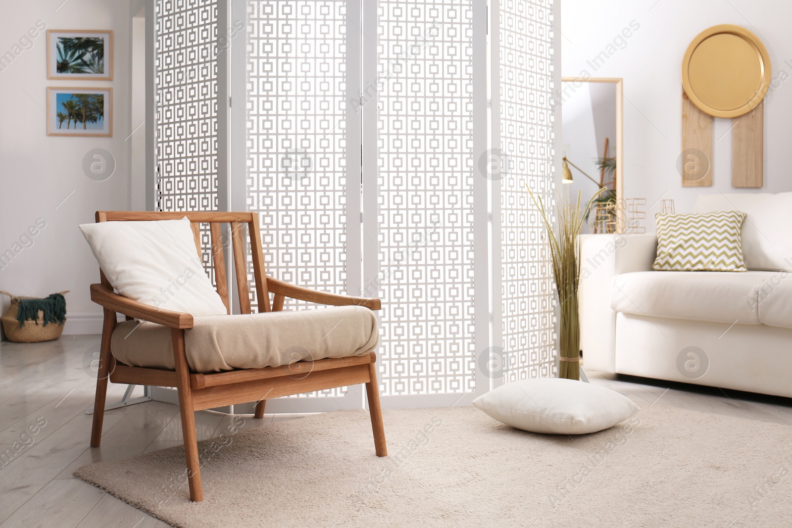 Photo of Stylish room interior with white folding screen and armchair