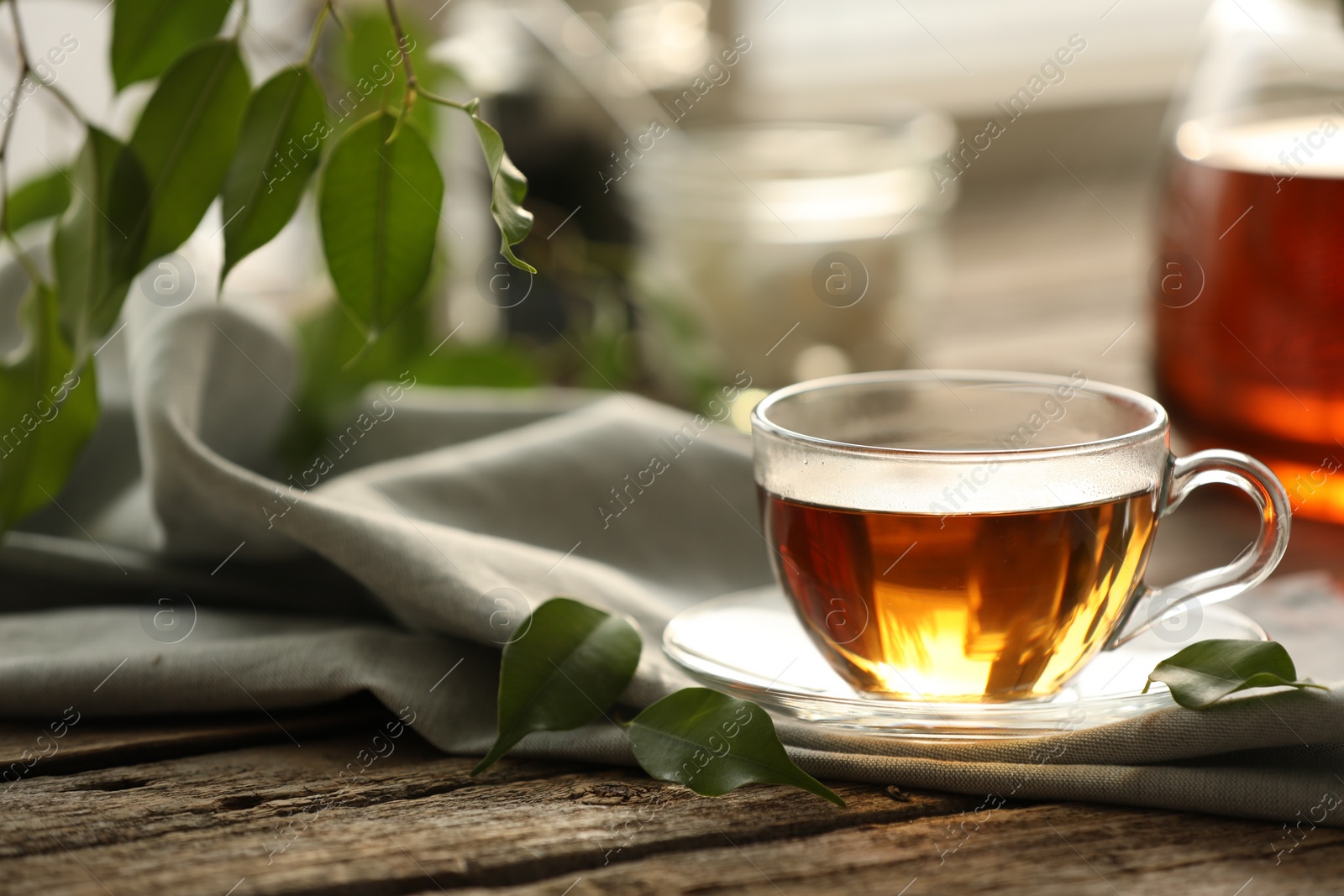 Photo of Tasty tea in cup on wooden table, closeup