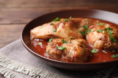 Photo of Tasty cooked rabbit meat with sauce and parsley on table, closeup