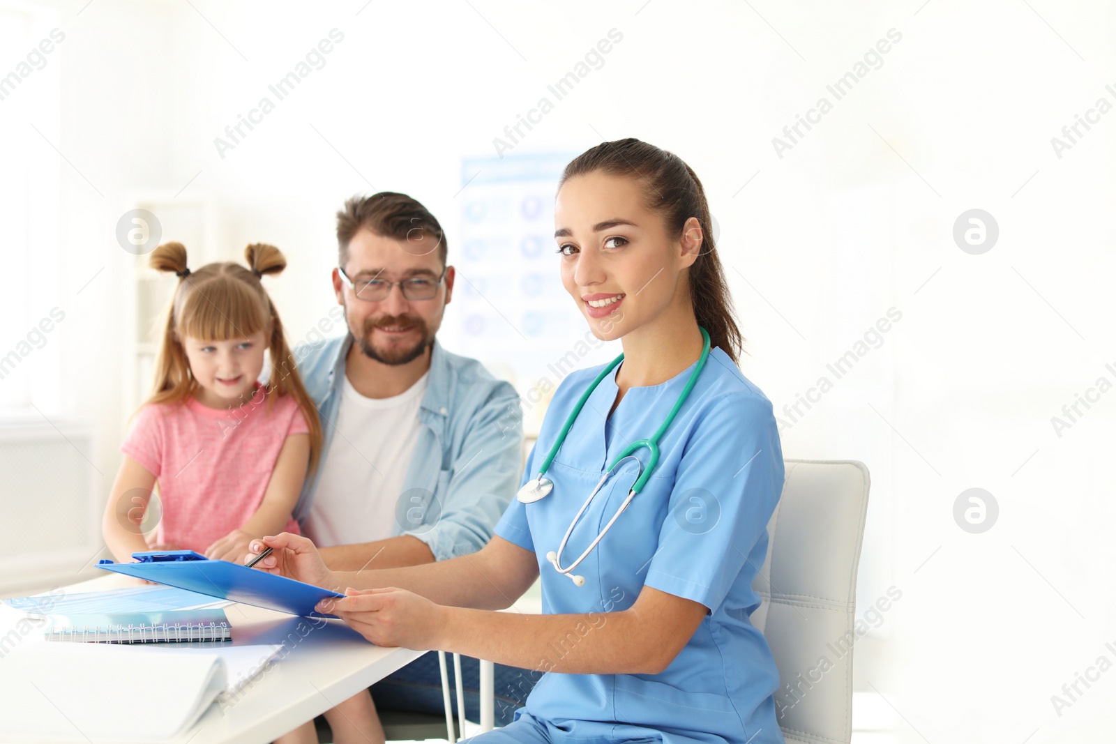 Photo of Little girl with father visiting children's doctor in hospital. Space for text