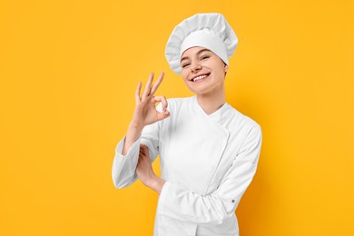 Photo of Professional chef showing OK gesture on yellow background