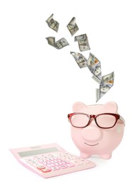 Image of Dollar banknotes falling into pink piggy bank with glasses and calculator on white background