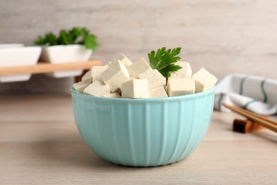 Delicious tofu with parsley on wooden table, closeup