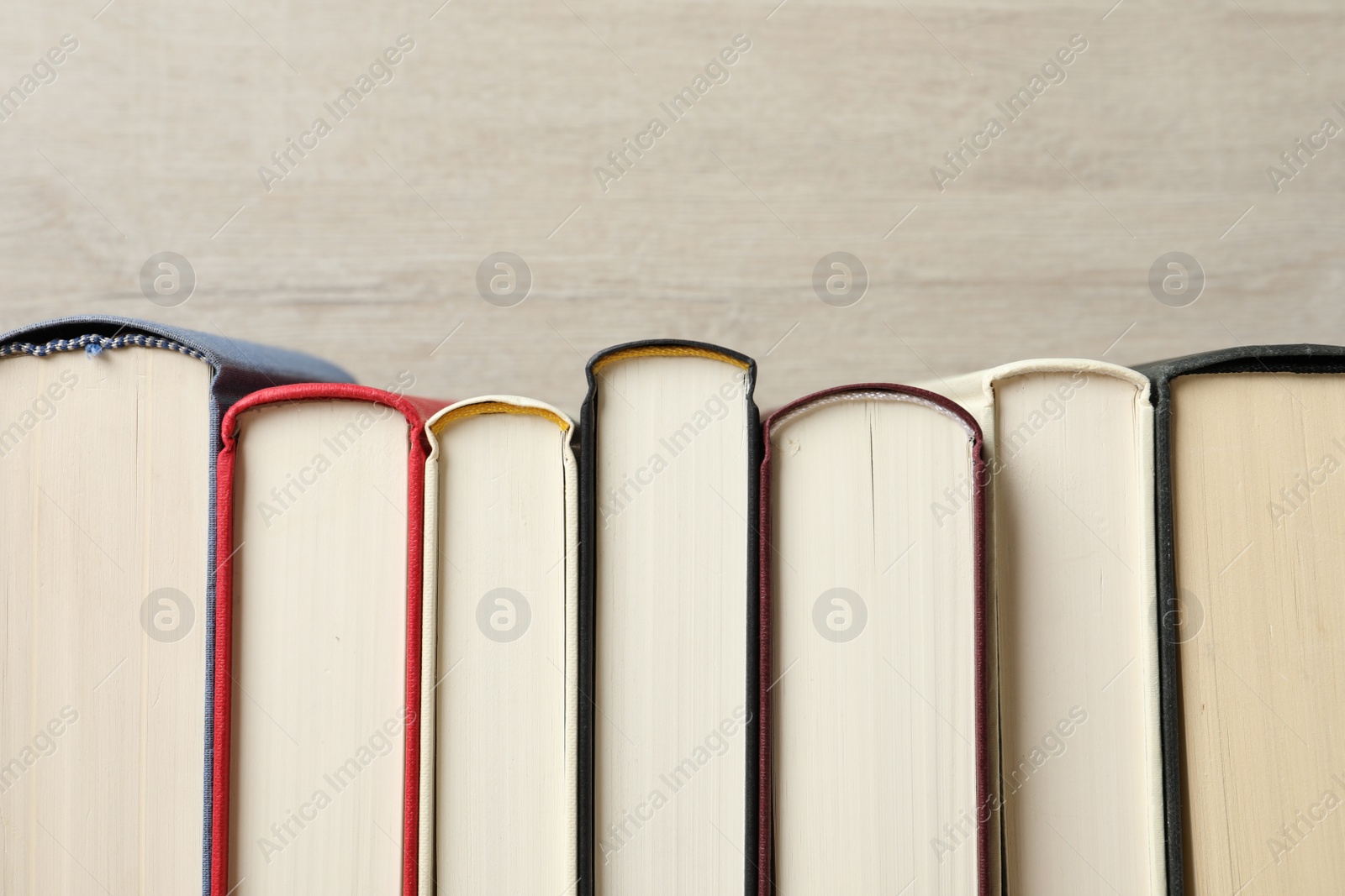 Photo of Many hardcover books on wooden background, space for text