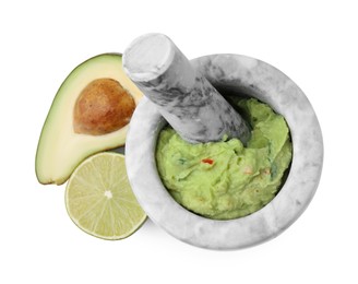 Photo of Mortar with delicious guacamole, avocado and lime isolated on white, top view