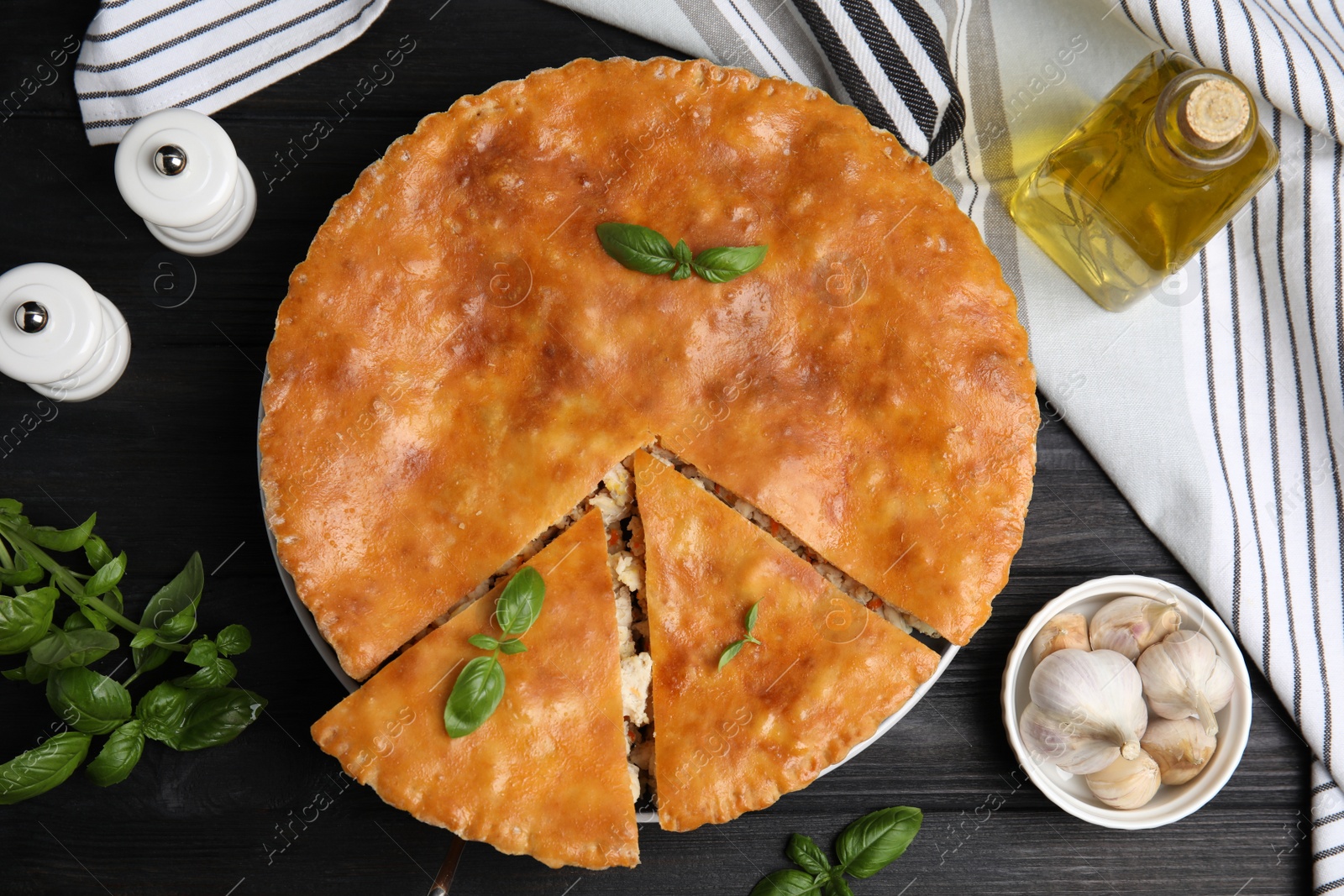 Photo of Delicious meat pie served on black wooden table, flat lay