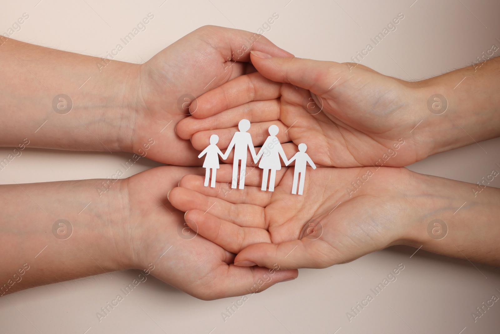 Photo of Couple holding paper family figures on beige background, top view. Insurance concept