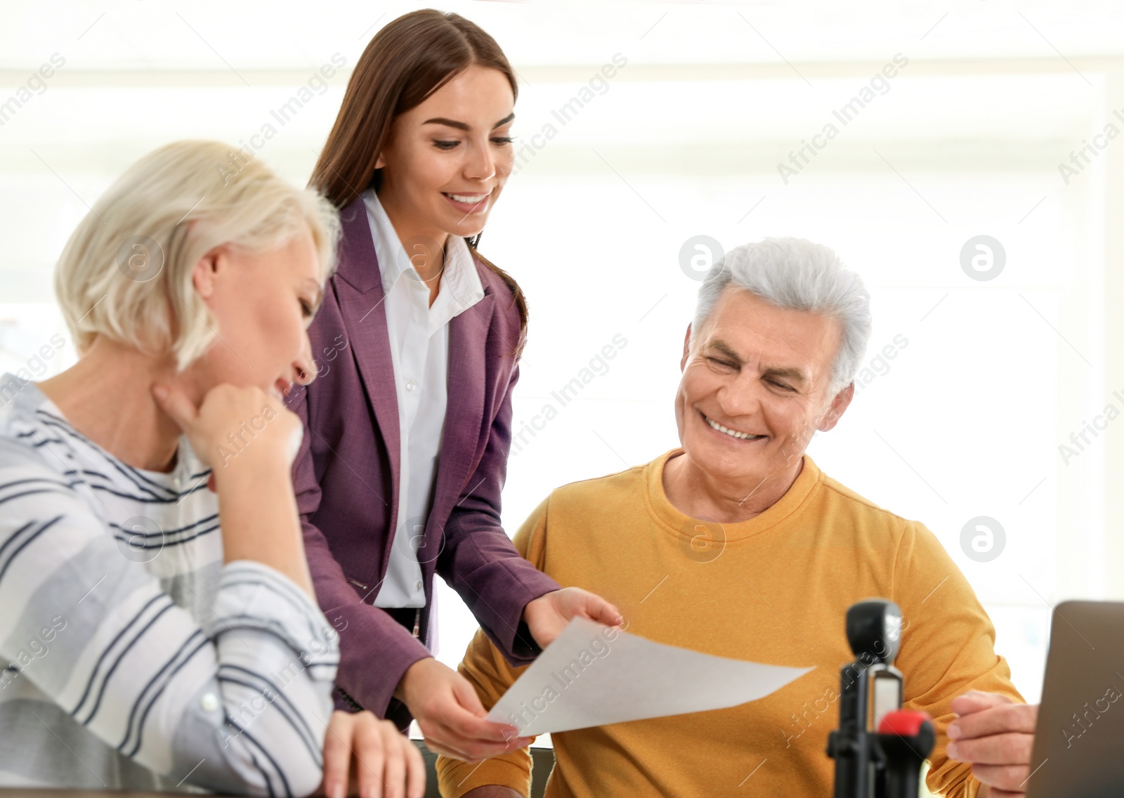 Photo of Female notary working with mature couple in office