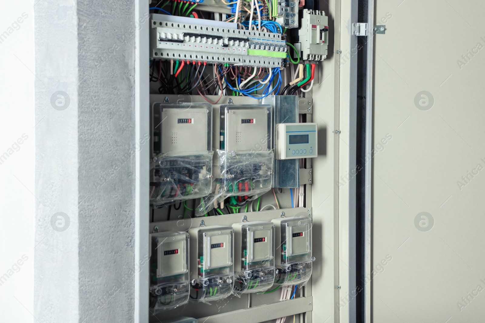 Photo of Open electrical fuse box with many electric meters