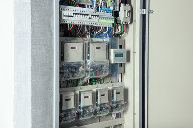 Photo of Open electrical fuse box with many electric meters