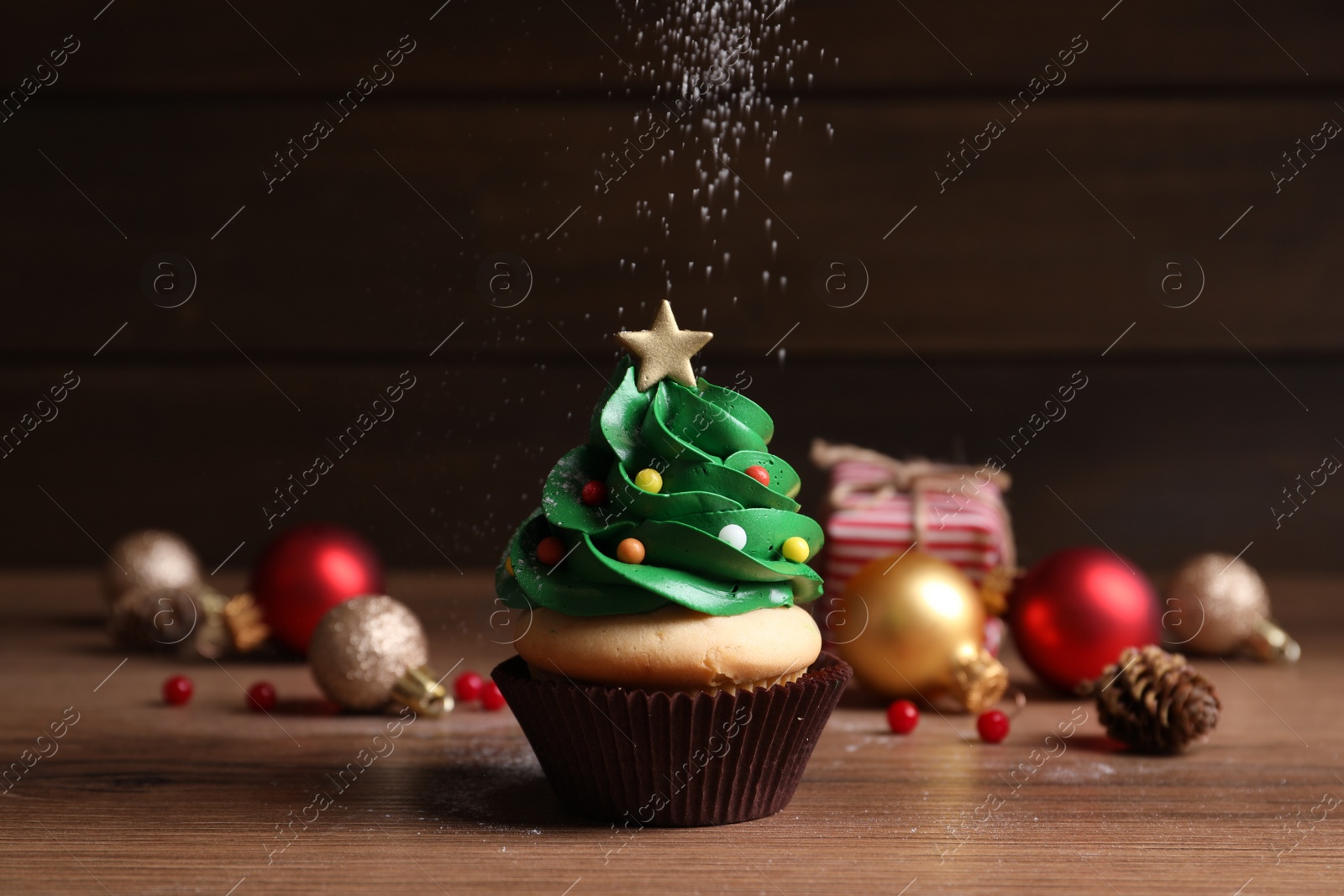 Photo of Sprinkling powdered sugar on Christmas tree shaped cupcake