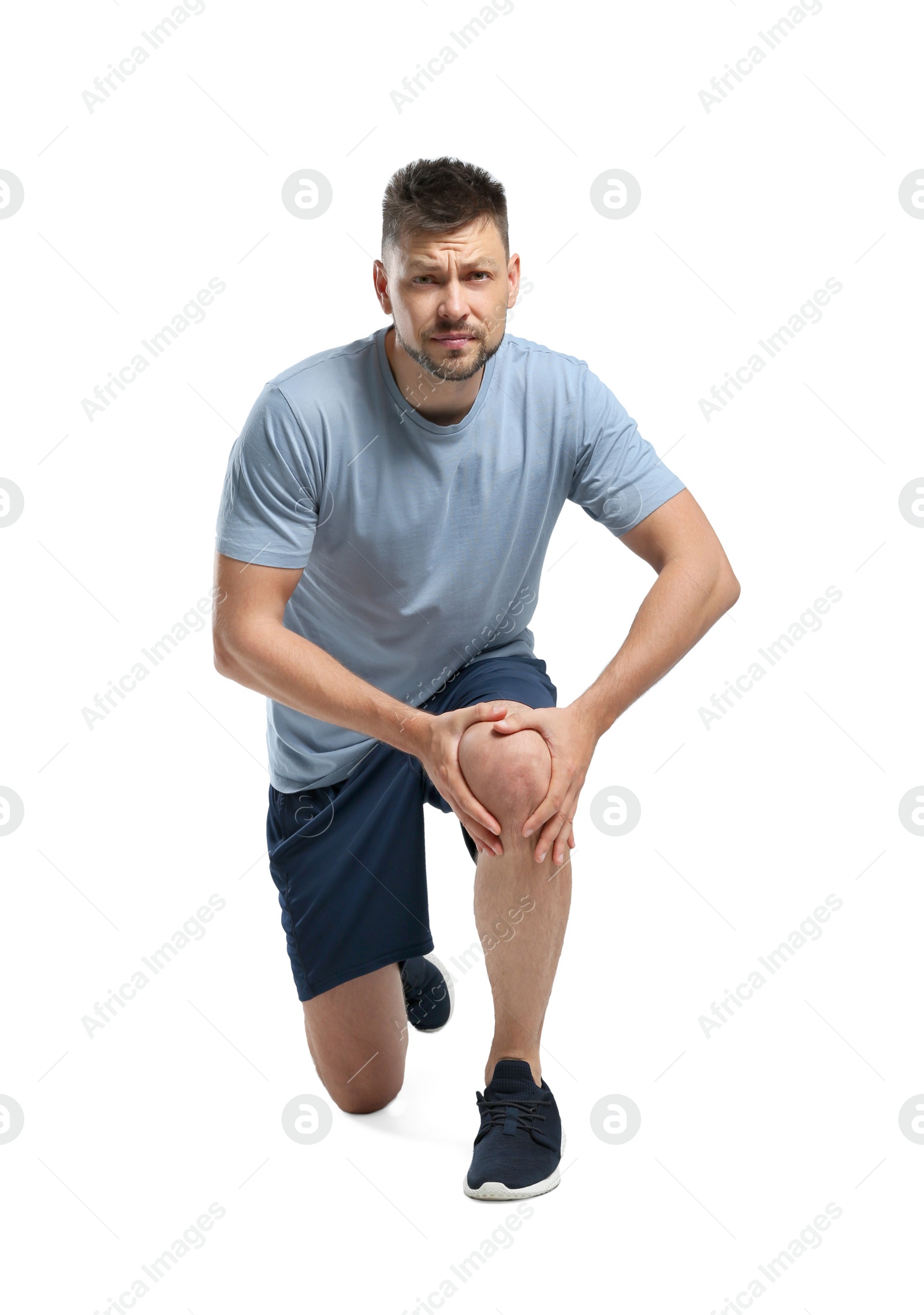 Photo of Full length portrait of sportsman having knee problems on white background